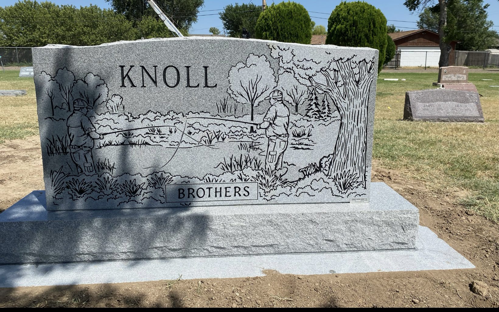 Gravestone with fishing scene engraving